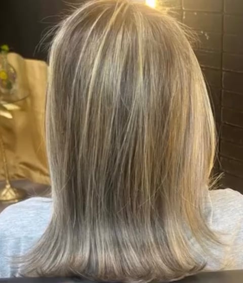 Back view of woman with shoulder-length, layered platinum blonde hair with soft waves