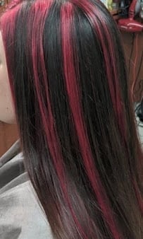 Long straight hair with alternating black and pink vertical stripes, shown from the back