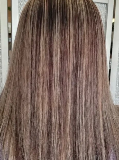 Back view of long straight hair with warm brown and highlighted tones