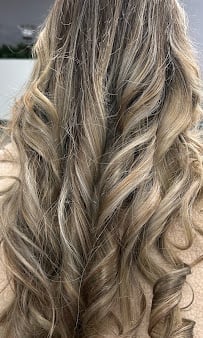 Long wavy blonde hair with dimensional highlights photographed from behind outdoors