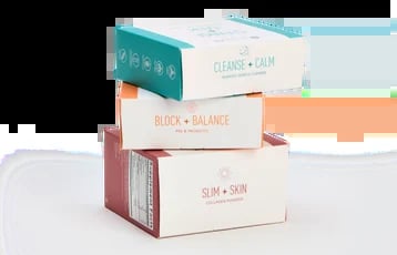 Stacked product boxes showing three wellness supplements: Cleanse + Calm in teal, Block + Balance in coral, and Slim + Skin in cream