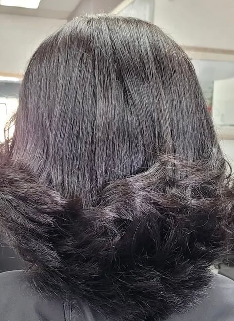 Back view of shoulder-length dark hair with layered styling and curled ends